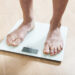 Healthy diet, fitness and weight loss concept. The legs of a young woman on the scales. Checking the weight.