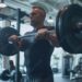 Man in His 40s Lifting Barbell in Modern Gym with Focus on Strength Training and Form